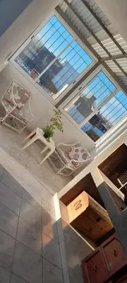 a living room with a table and some windows at calido descanso in Rio Cuarto