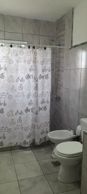 a bathroom with a toilet and a shower curtain at calido descanso in Rio Cuarto