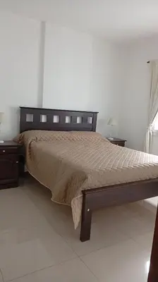 a bedroom with a large bed with a wooden frame at Apartamento villa Carlos Paz in Villa Carlos Paz