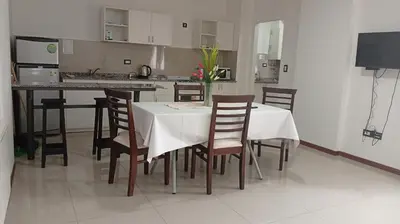 a dining room with a table and chairs and a kitchen at Apartamento villa Carlos Paz in Villa Carlos Paz