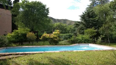 a swimming pool in the grass next to a house at Abedules VGB in Villa General Belgrano