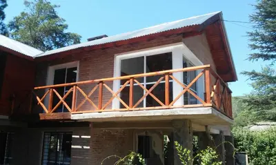 a house with a balcony on top of it at Abedules VGB in Villa General Belgrano