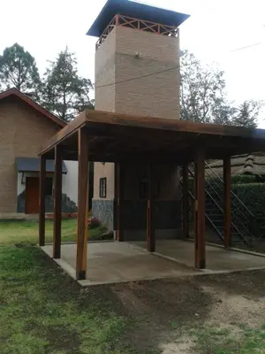 a pavilion in front of a building with a tower at Abedules VGB in Villa General Belgrano