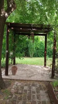 a wooden pavilion with a potted plant under a tree at Abedules VGB in Villa General Belgrano