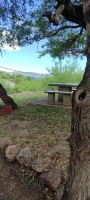 a park bench sitting next to a tree at CASA QUINTA en ESTANCIA VIEJA in Villa Carlos Paz