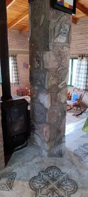 a stone fireplace in a living room with a tv at CASA QUINTA en ESTANCIA VIEJA in Villa Carlos Paz
