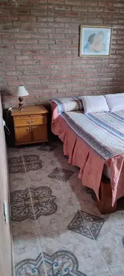 a bedroom with a bed and a table with a lamp at CASA QUINTA en ESTANCIA VIEJA in Villa Carlos Paz
