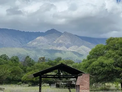 a brick building with mountains in the background at Reserva Ichacuna in Los Hornillos