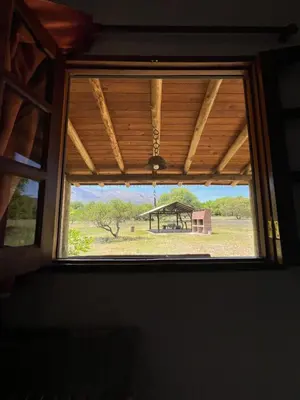 a window in a room with a view of a field at Reserva Ichacuna in Los Hornillos