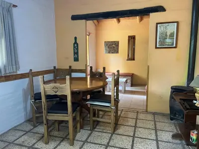a dining room with a wooden table and chairs at Reserva Ichacuna in Los Hornillos
