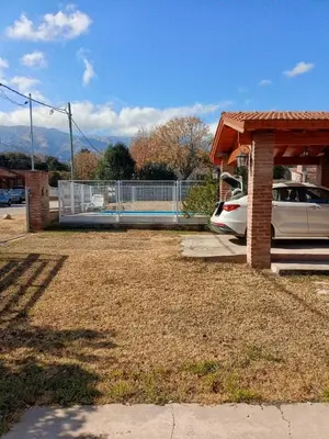 a house with a car parked in a driveway at Divina Providencia in Merlo