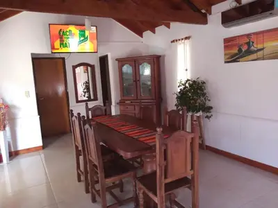 a dining room with a wooden table and chairs at Divina Providencia in Merlo