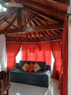 a blue couch in a room with red curtains at Divina Providencia in Merlo