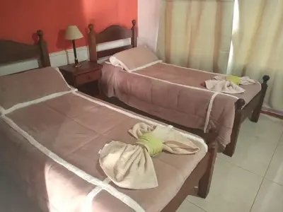 two beds in a room with towels on them at Divina Providencia in Merlo