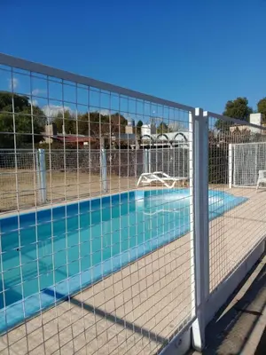 a swimming pool with a fence around it at Divina Providencia in Merlo