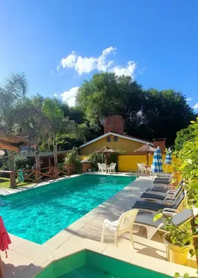 a swimming pool with chairs and a house at Complejo Pueblo Bonito Mayu Sumaj in San Antonio de Arredondo