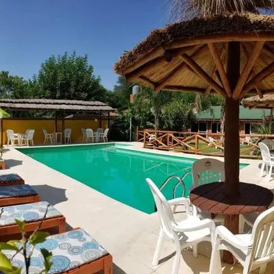 a resort with a swimming pool with chairs and a umbrella at Complejo Pueblo Bonito Mayu Sumaj in San Antonio de Arredondo