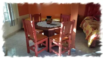 a dining room table with four chairs and a vase on it at Complejo Pueblo Bonito Mayu Sumaj in San Antonio de Arredondo