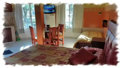 a bedroom with a bed and a table and chairs at Complejo Pueblo Bonito Mayu Sumaj in San Antonio de Arredondo