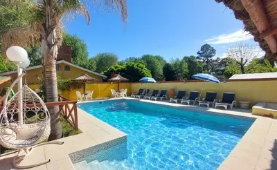 a swimming pool with chairs and a hammock next to a house at Complejo Pueblo Bonito Mayu Sumaj in San Antonio de Arredondo