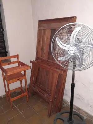 a fan next to a chair and a wooden cabinet at casa para 10 exc ubicacion garage 3 autos in Cordoba