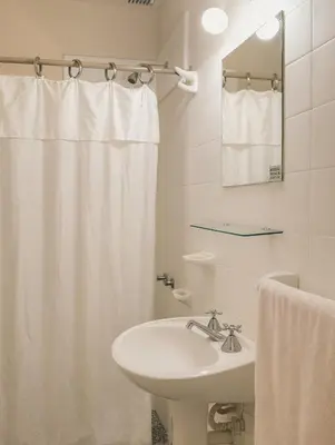 a white bathroom with a sink and a shower curtain at casa para 10 exc ubicacion garage 3 autos in Cordoba