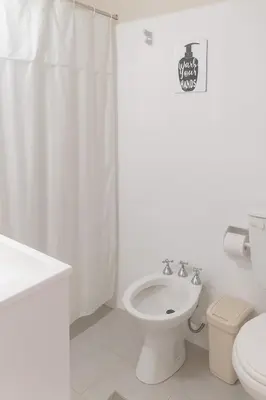 a white bathroom with a toilet and a sink at casa para 10 exc ubicacion garage 3 autos in Cordoba