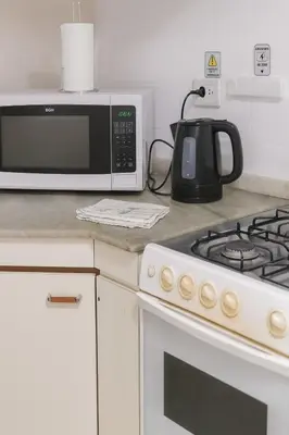 a kitchen counter with a microwave and a stove at casa para 10 exc ubicacion garage 3 autos in Cordoba