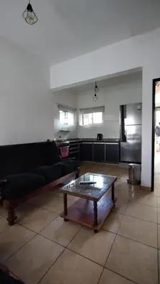 a living room with a black couch and a coffee table at EL REFUGIO DE MERLO, alquiler temporario in Merlo
