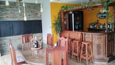 a dining room with a table and a bar at EL REFUGIO DE MERLO, alquiler temporario in Merlo