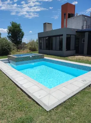 a swimming pool in front of a house at EL REFUGIO DE MERLO, alquiler temporario in Merlo