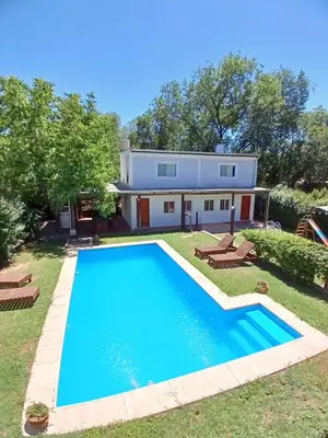 a large swimming pool in front of a house at Cabañas El Nogal in Villa Anizacate