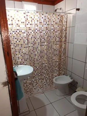 a bathroom with a shower and a toilet and a sink at Cabañas El Nogal in Villa Anizacate