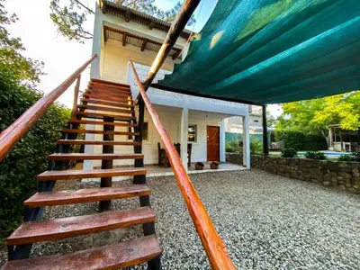 a staircase leading to a house with a blue awning at Cabañas El Nogal in Villa Anizacate