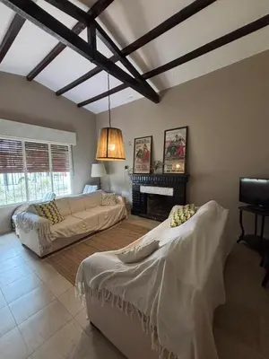 a living room with two beds and a fireplace at Casa Paz in Villa Carlos Paz