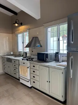 a kitchen with a refrigerator and a stove top oven at Casa Paz in Villa Carlos Paz