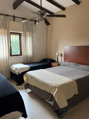 a bedroom with two beds and a ceiling fan at Casa Paz in Villa Carlos Paz
