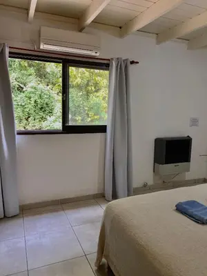 a bedroom with a bed and a window and a tv at Departamento Matrimonial Merlo San luis in Merlo
