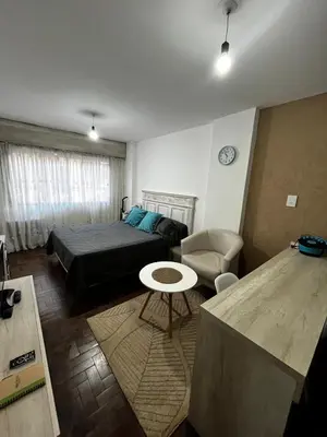 a bedroom with a bed and a table and a couch at El Abrojal 4 - Monoambiente Céntrico, zona Patio Olmos in Cordoba