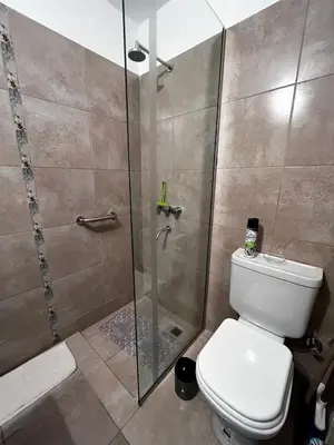 a bathroom with a toilet and a glass shower at El Abrojal 4 - Monoambiente Céntrico, zona Patio Olmos in Cordoba