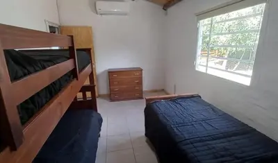 a bedroom with a bed and a dresser and a window at Cabaña Don Leonardo in Santa Rosa de Calamuchita