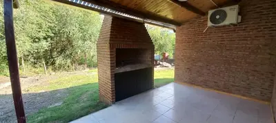 an outdoor patio with a brick fireplace with a speaker at Cabaña Don Leonardo in Santa Rosa de Calamuchita