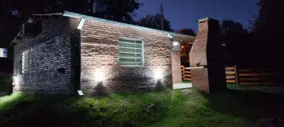 a brick house with lights on the side of it at Cabaña Don Leonardo in Santa Rosa de Calamuchita