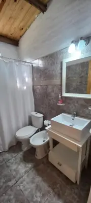 a bathroom with a toilet and a sink at Cabaña Don Leonardo in Santa Rosa de Calamuchita