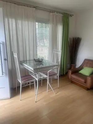 a dining room with a glass table and two chairs at Jardín del norte a mts de sanatorio Allende, Hospital Privado cerro,Nascentis y estadio Kempes in Cordoba