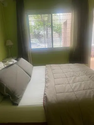 a bedroom with a large bed with a window at Jardín del norte a mts de sanatorio Allende, Hospital Privado cerro,Nascentis y estadio Kempes in Cordoba