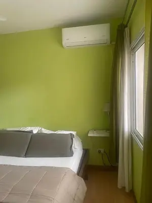 a green bedroom with a bed and a window at Jardín del norte a mts de sanatorio Allende, Hospital Privado cerro,Nascentis y estadio Kempes in Cordoba