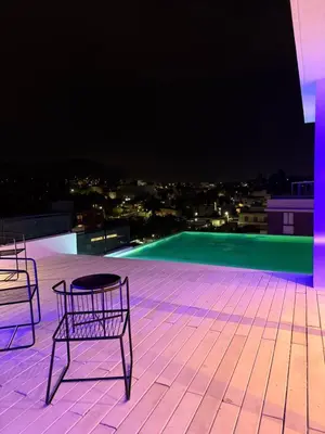 two chairs and a table on a roof at night at Departamento moderno pleno centro con pileta y cochera privada in Villa Carlos Paz