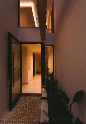 a hallway of a building with a door and plants at Departamento moderno pleno centro con pileta y cochera privada in Villa Carlos Paz