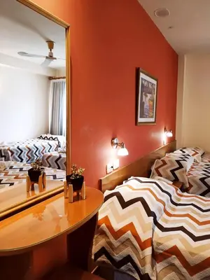 a bedroom with two beds and a mirror at Gran Lourdes Hotel in Villa Carlos Paz